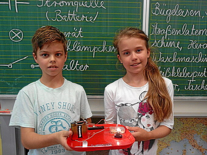 Anton und Lilli mit dem von der Klasse gebauten Stromkreislauf.