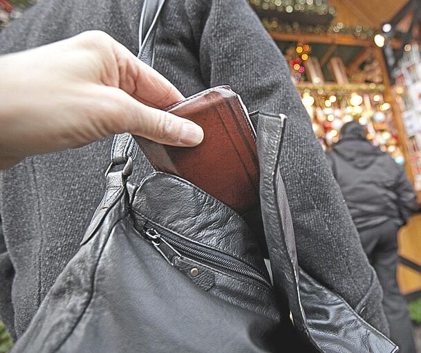 Eine Geldbörse wird aus einer Tasche gezogen. Eine Geldbörse wird aus einer Tasche gezogen.