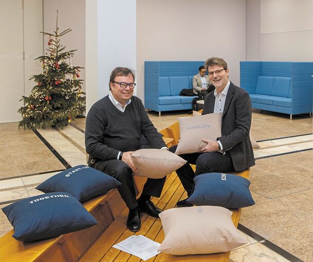 Rainer Kallenbach (links) und Rolf Nicodemus, die Leiter des neuen Bosch-Standorts, testen das zur Sitzgelegenheit umgestaltete Boot im Eingangsbereich des Bürogebäudes.