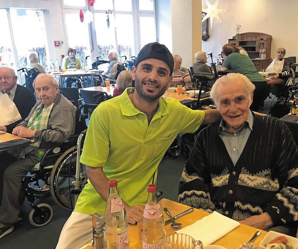 Nasir Ahmad Hajimohamad bei seiner Arbeit im Speisesaal des Seniorenstifts Marbach mit einem Bewohner.