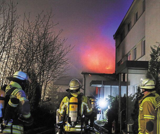 Flammen schlagen aus dem Dach des Bürogebäudes, das an ein Wohnhaus angebaut ist. Foto: Alfred Drossel