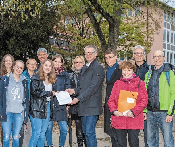 Schülersprecherin Greta Kleine (Vierte von links) überreicht Michael Ilk die Unterschriftenliste. Mit dabei sind Schülerinnen, Rektor Wolfgang Medinger (hinten), Elternbeiratsvorsitzende Christina Mellahn (Dritte von rechts) und Schülersprecher Nils