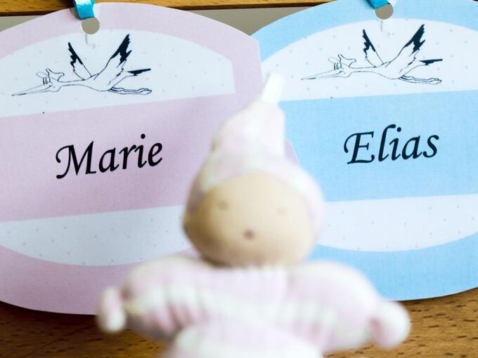 Puppe liegt vor zwei Zetteln mit Aufschrift «Marie» und «Elias»