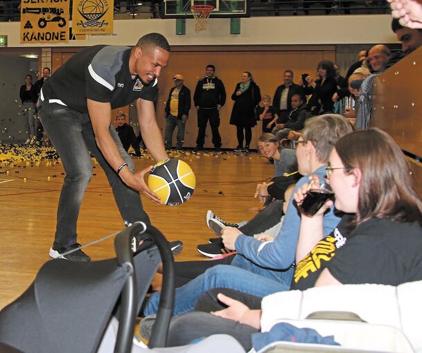 Kapitän David McCray verschenkt einen unterschriebenen Ball als Andenken an einen Riesen-Fan in der Rundsporthalle.Foto: Baumann