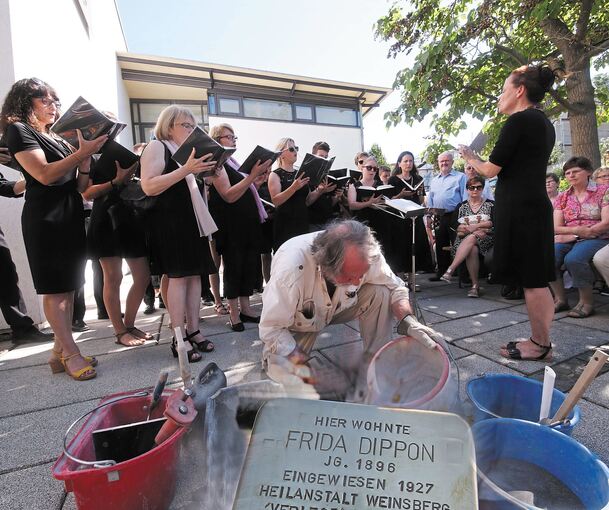 Gunter Demnig verlegt den Stolperstein für Frida Dippon, im Hintergrund singt der Gemeindechor der neuapostolischen Kirche. Foto: Alfred Drossel