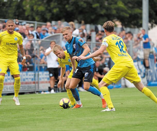Der Bissinger Sebastian Gleißner (Mitte) nimmt es mit drei Kickers-Spielern auf. Foto: Baumann
