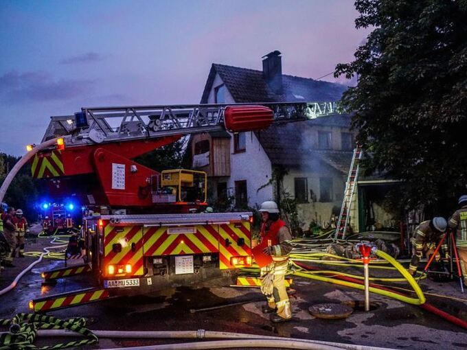 Feuerwehrkräfte bekämpfen einen Brand an einem Einfamilienhaus