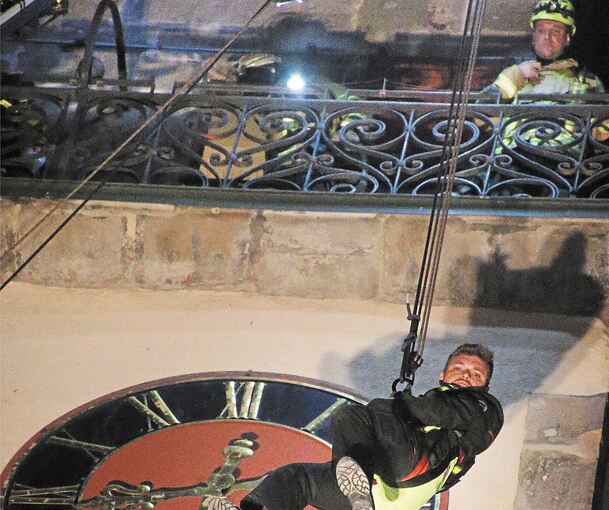 Höhepunkt der nächtlichen Übung: Feuerwehrmann Matthias Röder hängt am Seil und lässt sich vom Kirchturm abseilen.Foto: Alfred Drossel