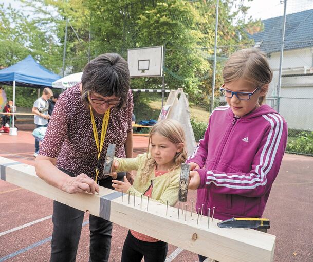 Bunter Nachmittag mit Spiel und Spaß: Kinder hämmern Nägel ins Holz. Foto: Holm Wolschendorf