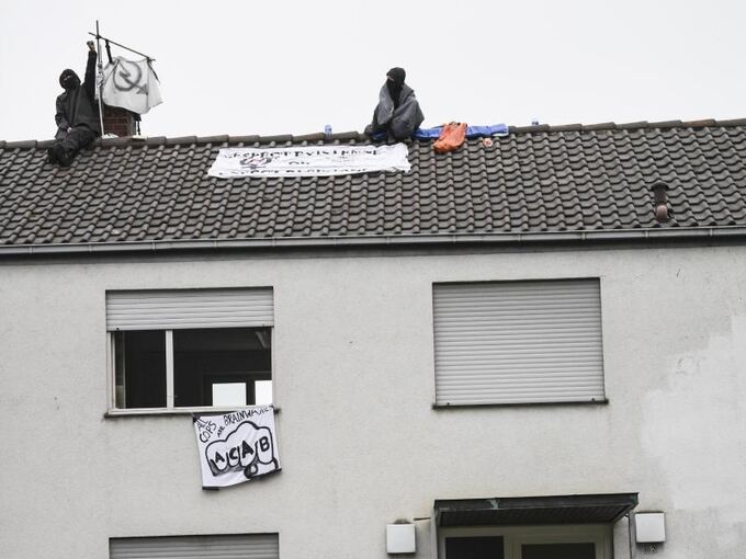 Zwei Aktivisten sitzen auf dem Dach einer ehemaligen Polizeiwache