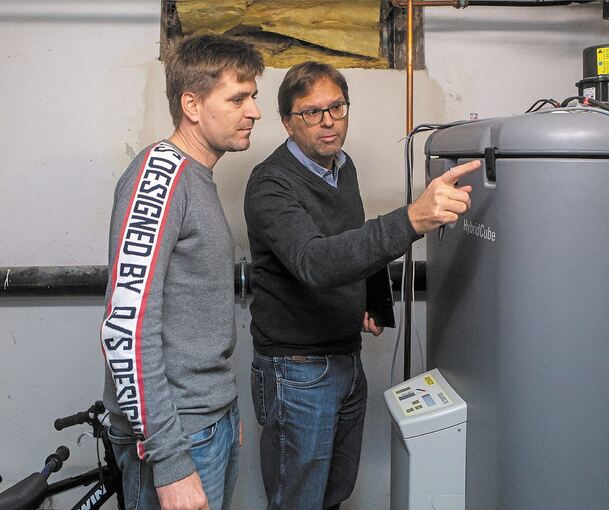Sven Roth von der Ludwigsburger Energieagentur (rechts) und René Kucher schauen sich die Wärmepumpe im Keller der Familie an. Foto: Oliver Bürkle