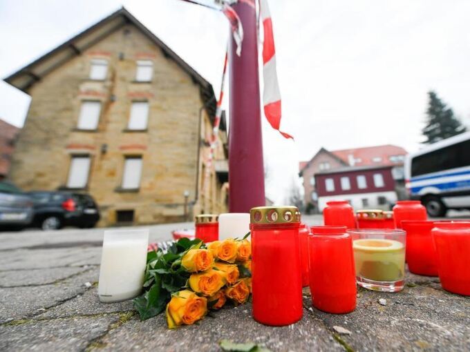Blumen und Kerzen stehen vor dem Tatort in Rot am See