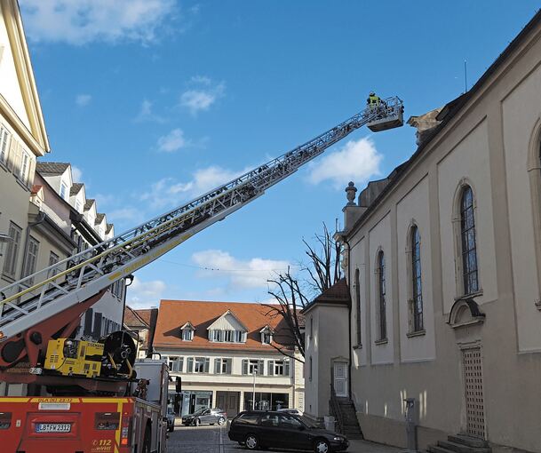 Bei der katholischen Dreieinigkeitskirche am Marktplatz muss die Feuerwehr das Dach sichern – ein paar Ziegel haben sich gelöst und sind nach unten gefallen. Der Platz um die Kirche war auch gestern noch abgesperrt.