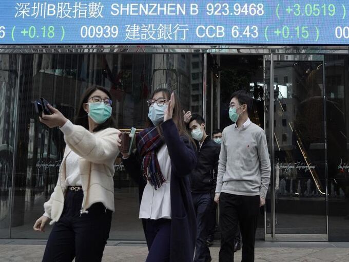 Personen mit Mundschutz gehen über eine Straße in China
