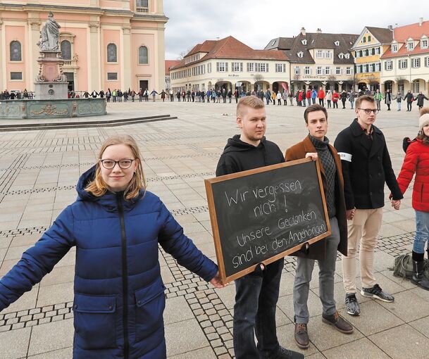 Den gesamten Marktplatz umfasst die Menschenkette, mit der Solidarität für die Opfer in Hanau ausgedrückt werden soll. Foto: Ramona Theiss