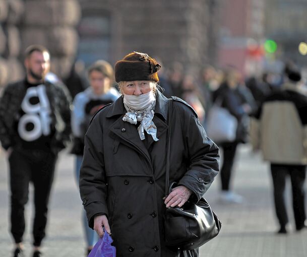 Besonders für ältere Menschen ist das Coronavirus gefährlich: Eine ältere Frau mit einem Mundschutz geht in Kiew/Ukraine eine Straße entlang. Foto: Sergei Chuzavkov/dpa