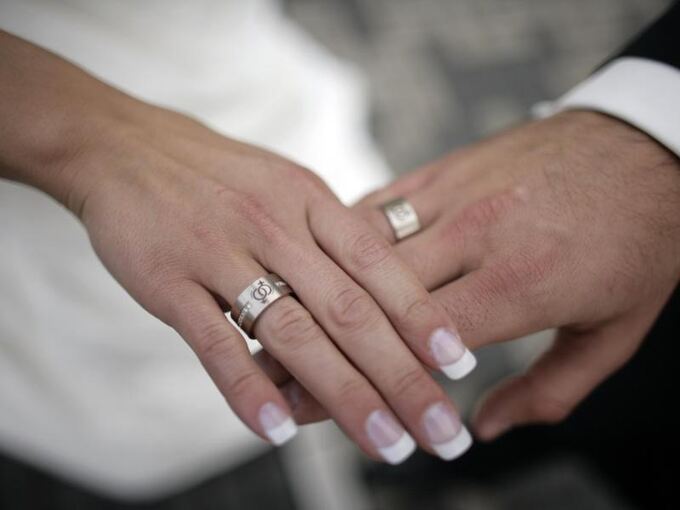 Ein Brautpaar legt nach dem Ringtausch die Hände übereinander