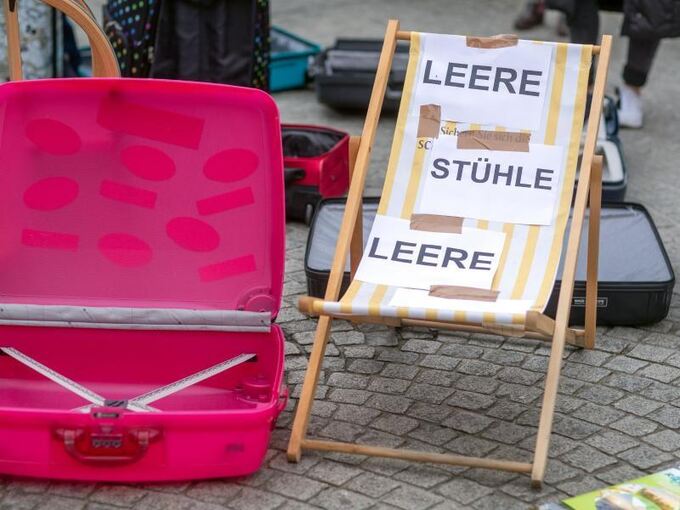 Leere Koffer und Liegestühle bei einer Demonstration