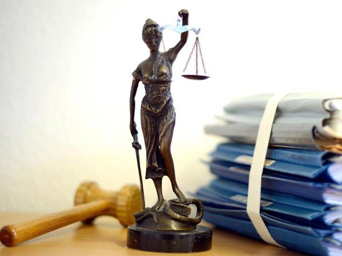 Eine Justitia-Figur steht auf einem Schreibtisch