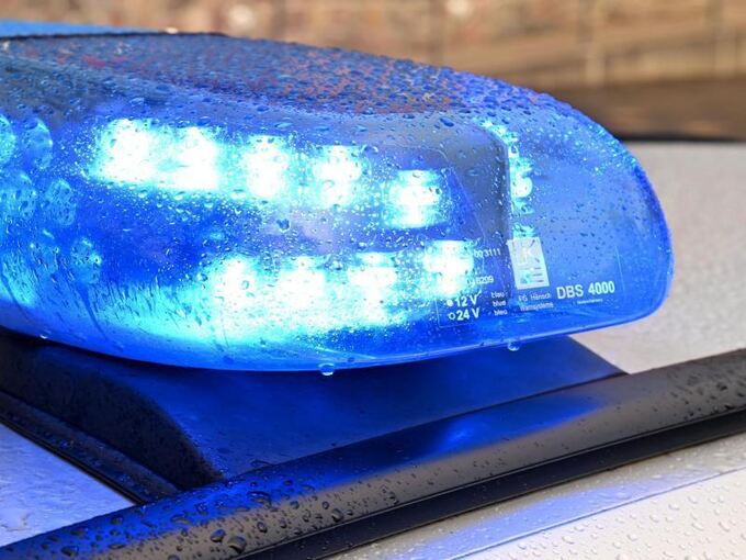 Ein Streifenwagen der Polizei steht mit Blaulicht am Straßenrand