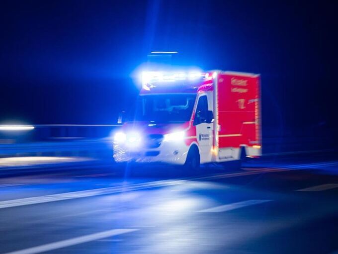 Ein Rettungswagen fährt mit Blaulicht durch eine Straße