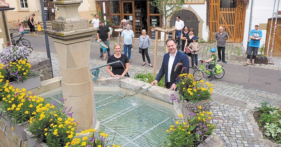 Oberbürgermeister Matthias Knecht und Stephanie Lin von der Firma Goetze freuen sich zusammen mit den Hohenecker Bürgern über den sprudelnden Brunnen. Foto: Holm Wolschendorf