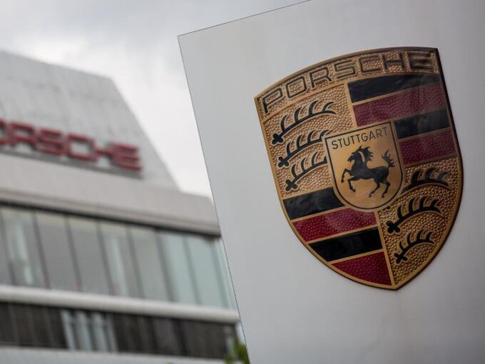 Das Porsche Logo vor einem Gebäude des Automobilherstellers