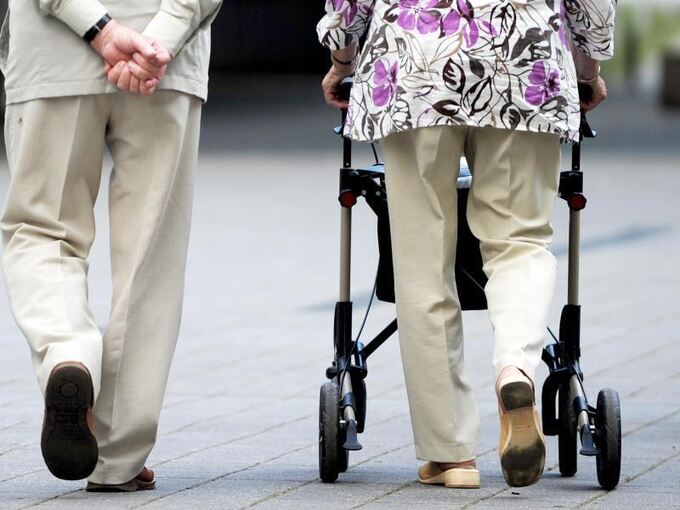 Eine Seniorin und ein Senior gehen gemeinsam spazieren