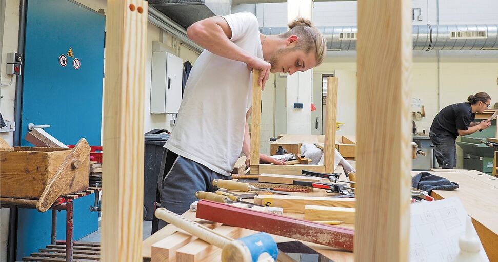 Frieder Stahl (21) fertigt in der Prüfung einen Hocker aus Massivholz an.