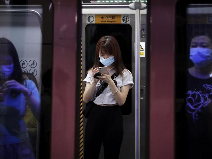 Menschen in der Pekinger U-Bahn tragen Mundschutz