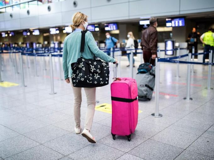 Eine Frau geht zum Check-in-Schalter am Düsseldorfer Flughafen