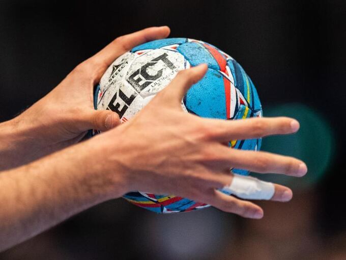 Ein Handballer hält den Spielball in den Händen