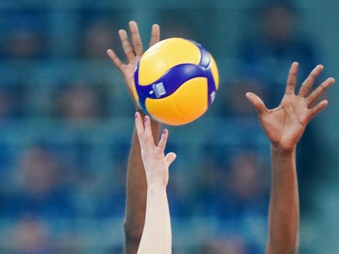 Händen greifen in einem Spiel nach einem Volleyball