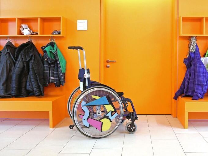 Ein Rollstuhl steht vor einem Klassenzimmer