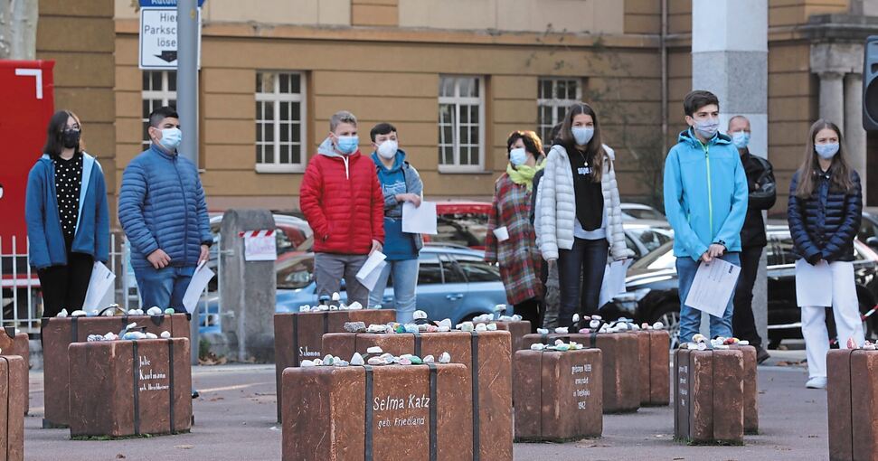 Mit bemalten Steinen, die auf den Koffern abgelegt werden, erinnern die Schüler an die NS-Opfer. Foto: Ramona Theiss