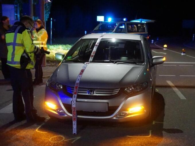 Polizisten stehen nach einem Unfall an einem Honda