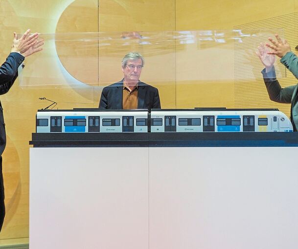 Hellgrau mit gelben und blauen Farbfeldern statt Rot: Regionalpräsident Thomas Bopp (Mitte) inspiziert das neue Design der S-Bahn. Foto: Holm Wolschendorf