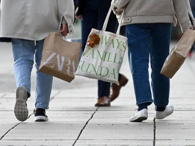 Zwei Frauen gehen mit Einkaufstüten über die Königstraße