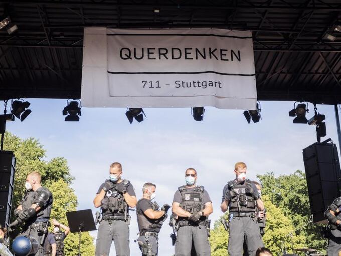 Polizisten stehen unter einem Banner von «Querdenken 711»