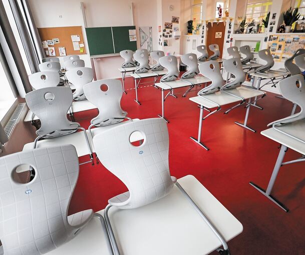 Hochgestellt sind die Stühle in einem leeren Klassenzimmer. Der Unterricht muss digital stattfinden. Foto: Jan Woitas/dpa