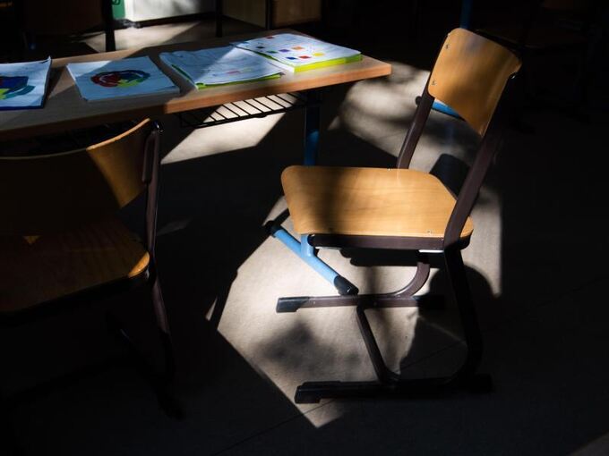 Stuhl auf Tisch in leerem Klassenzimmer
