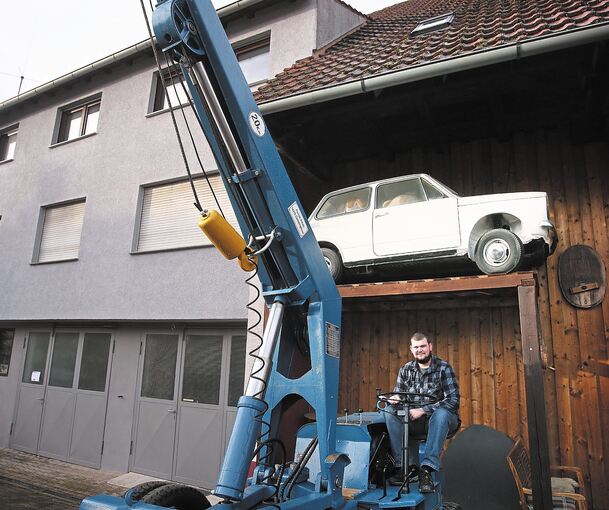 Er hat in die Restaurierung viel Zeit investiert: Patrick Scholz mit seinem Demag V 25. Oben ist der japanische Kleinstwagen Carol P 360 zu sehen, an dem noch gearbeitet werden muss.Foto: Alfred Drossel