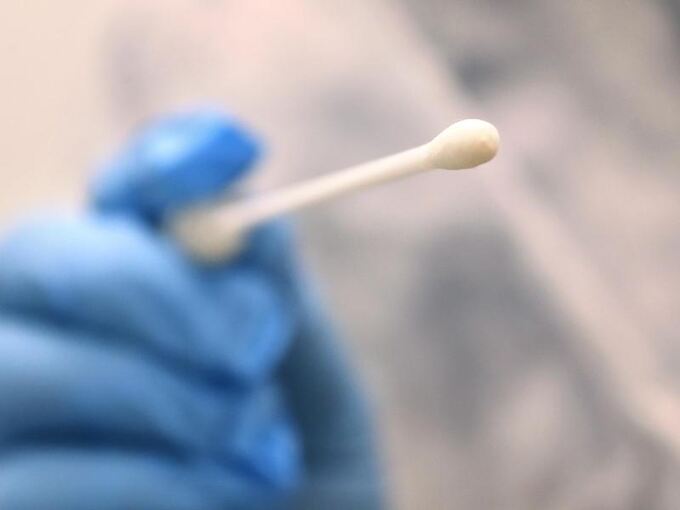 Ein Arzt hält einen Tupfer zum Abstrich für einen Corona-Test