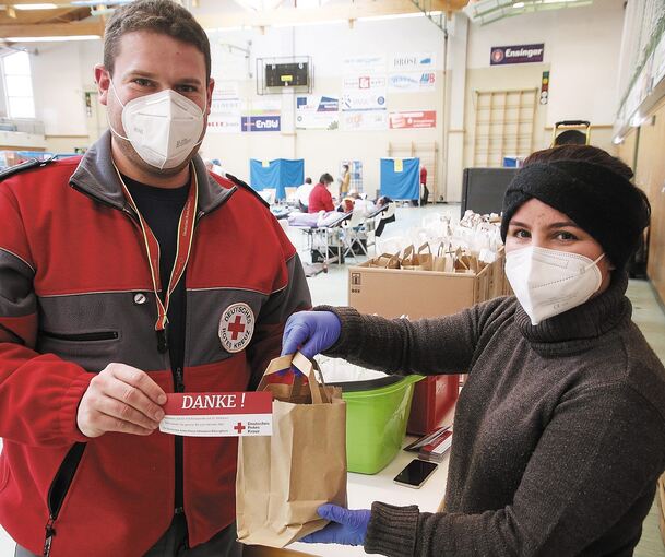 Bereitschaftsleiter Jens Kübler und Helferin Gonna beim Austeilen der Lunchpakete.