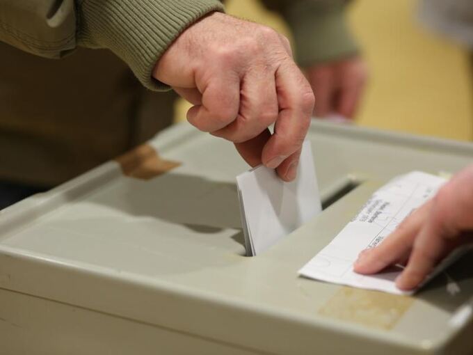Ein Wahlberechtigter steckt seinen Stimmzettel in die Wahlurne
