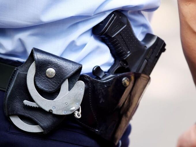 Polizist trägt Handschellen