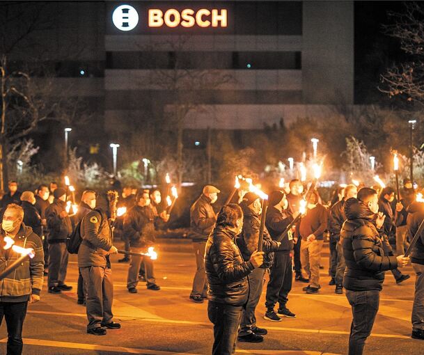 Mitarbeiter von Bosch mit Fackeln vor dem Bosch-Werk in Stuttgart-Feuerbach. Foto: Christoph Schmidt/dpa