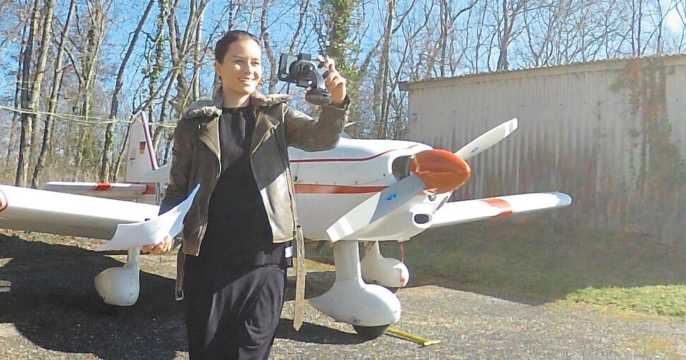 Juliane Ossadnik filmt sich für die Schüler vor dem Flugzeug.