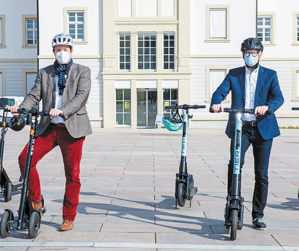 Oberbürgermeister Matthias Knecht (links) und Bürgermeister Michael Ilk präsentieren die E-Scooter im Rathaushof. Foto: Stadt Ludwigsburg/Benjamin Stollenberg