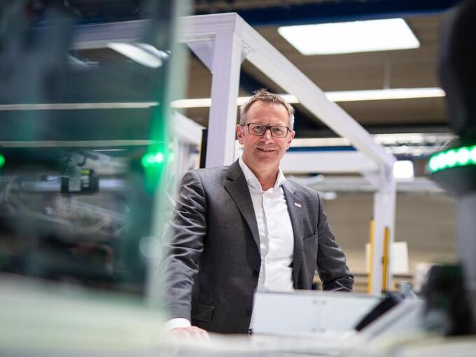 Rolf Najork steht neben einem modularen Bosch Fertigungssystem